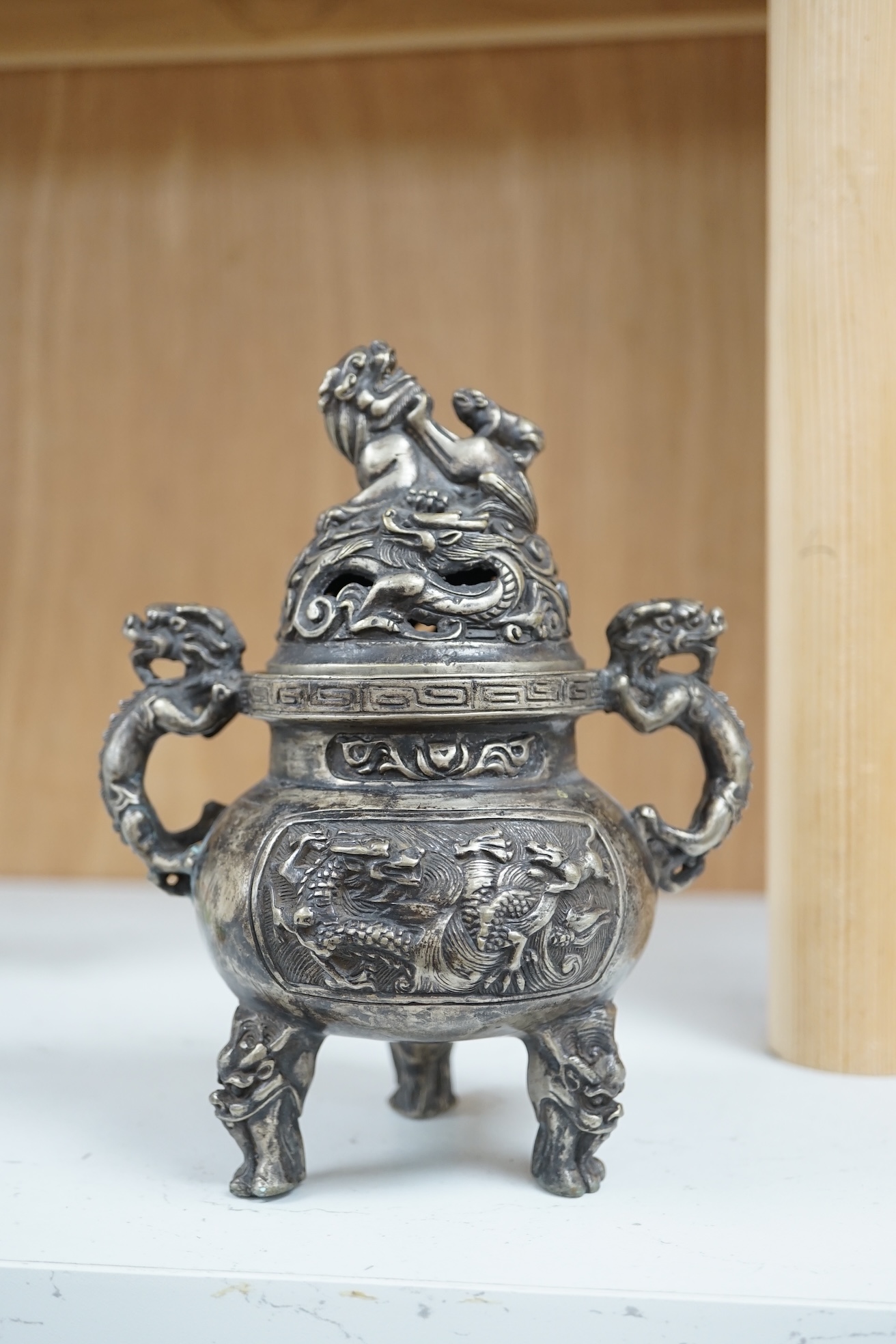 A Chinese silvered bronze lidded ‘dragon’ censer, 16cm tall. Condition - fair to good